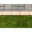 Rasenkante zwischen grauen Steinplatten und grünem Rasen