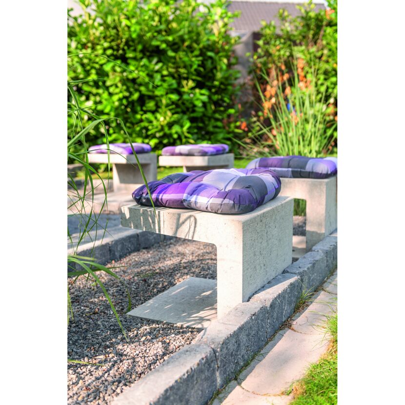 Sitzecke mit Betonwürfeln und Sitzkissen im Garten