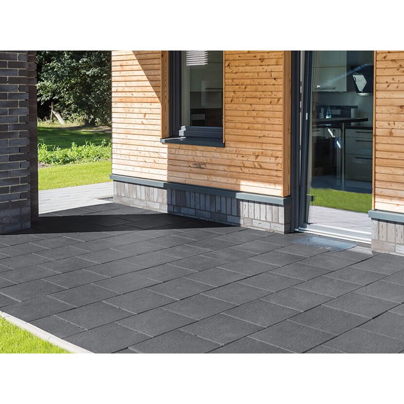 Graue Terrassenplatten vor einem Haus.