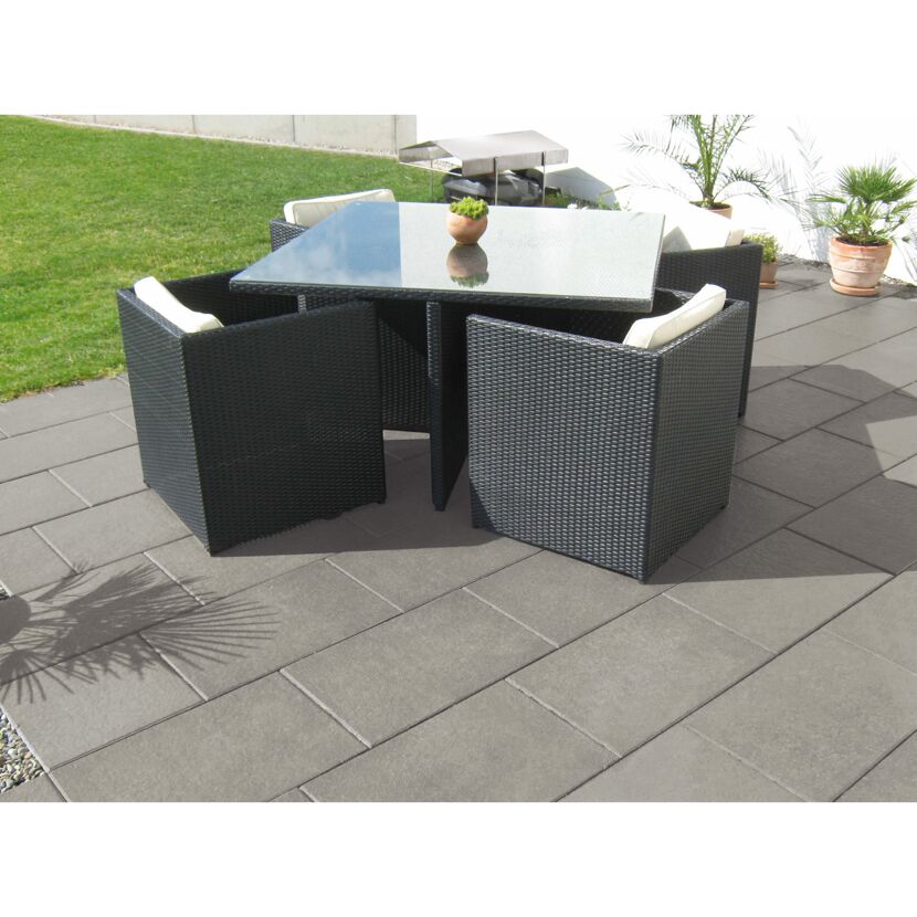 Schwarze Gartenmöbel auf grauen Terrassenplatten.