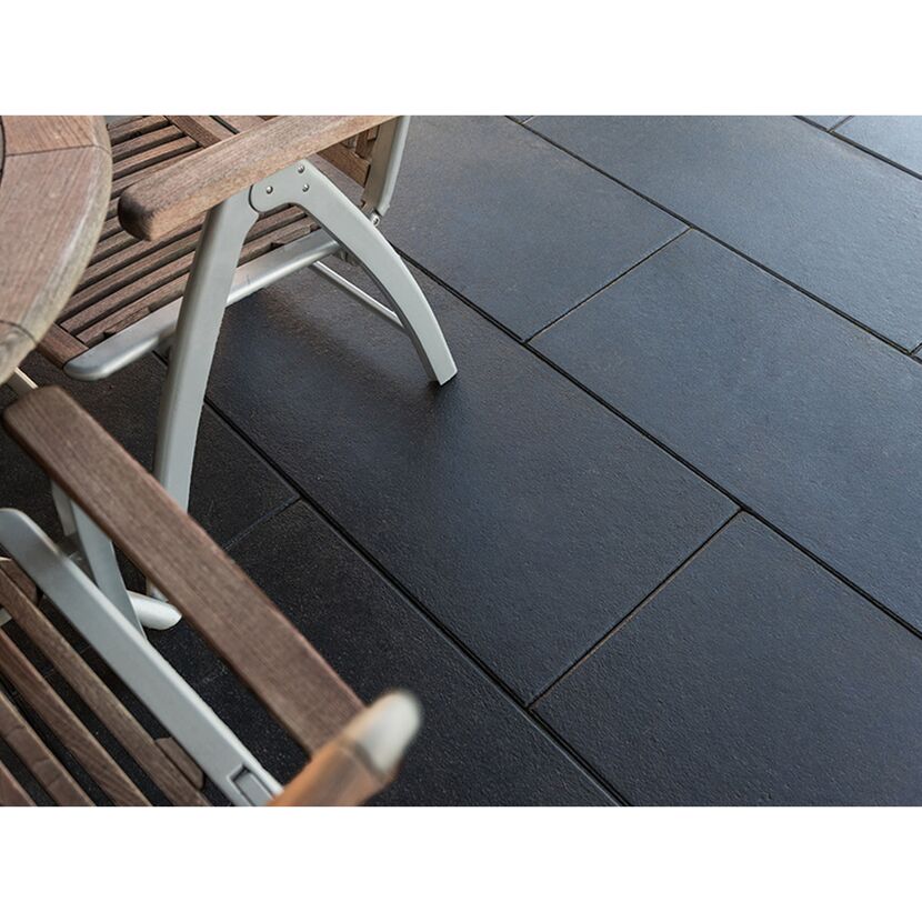 Schwarze Terrassenplatten mit Gartenmöbeln