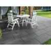 Weiße Gartenmöbel auf dunkler gepflasterter Terrasse