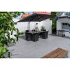 Gepflasterte Terrasse mit Esstisch und Sonnenschirm.