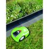 Mähroboter mäht Rasen neben Blumenbeet