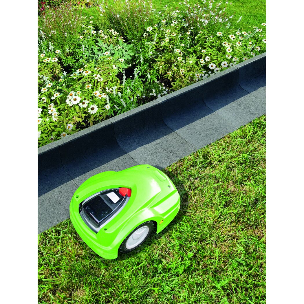 Mähroboter mäht Rasen neben Blumenbeet