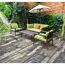 Gepflasterte Terrasse mit Gartenmöbeln und Sonnenschirm.