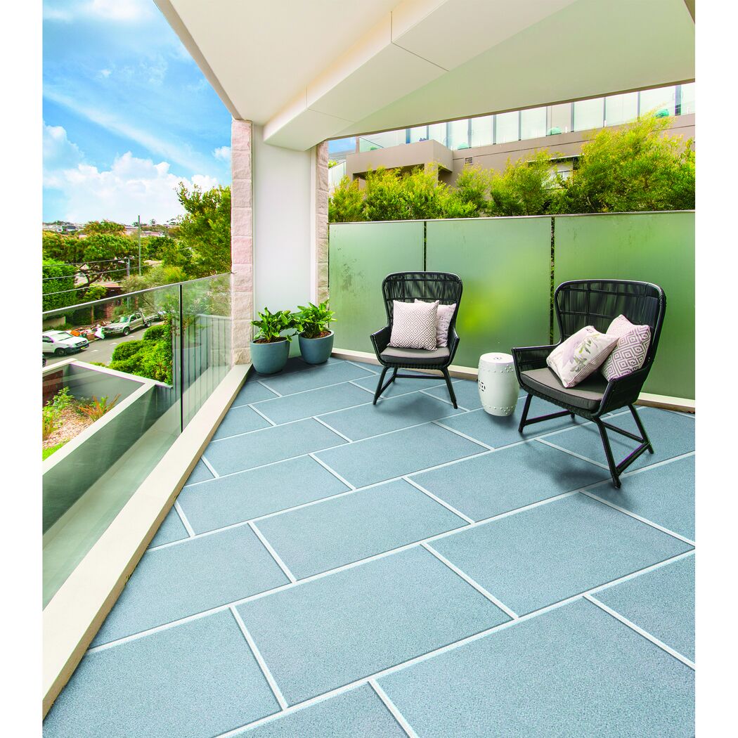 Zwei Stühle und Tisch auf Balkon mit Betonplatten