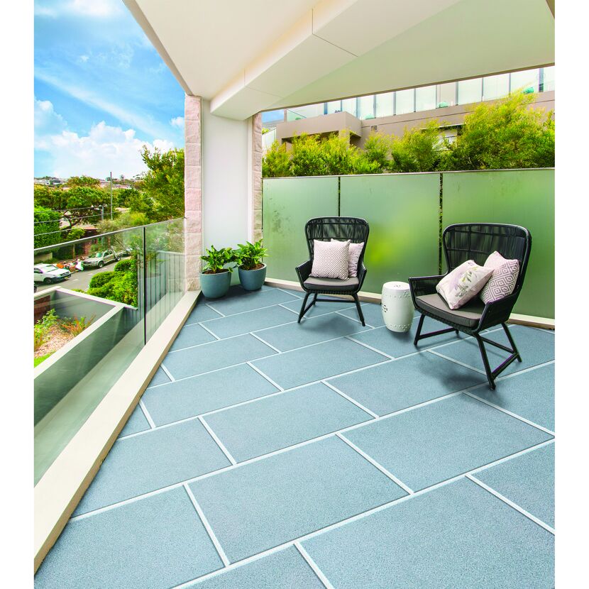 Zwei Stühle und Tisch auf Balkon mit Betonplatten
