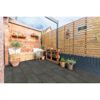 Gepflasterte Terrasse mit Holzmöbeln und Pflanzen.