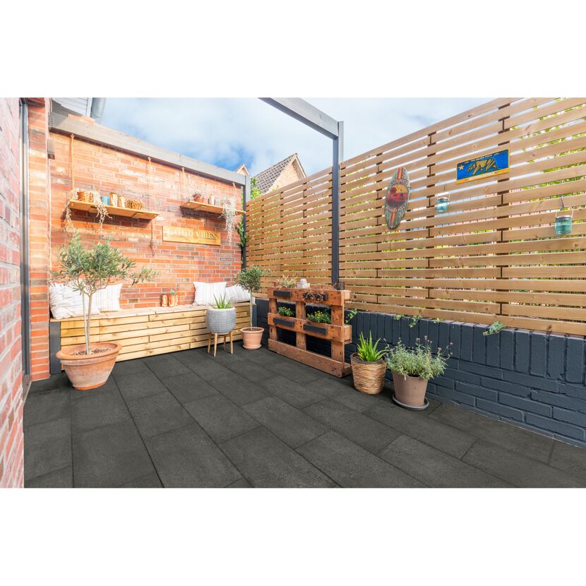 Gepflasterte Terrasse mit Holzmöbeln und Pflanzen.