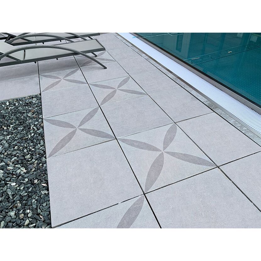 Poolumrandung aus grauen Platten mit floralem Muster