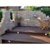Holzterrasse mit Wasserspiel und Steinwand