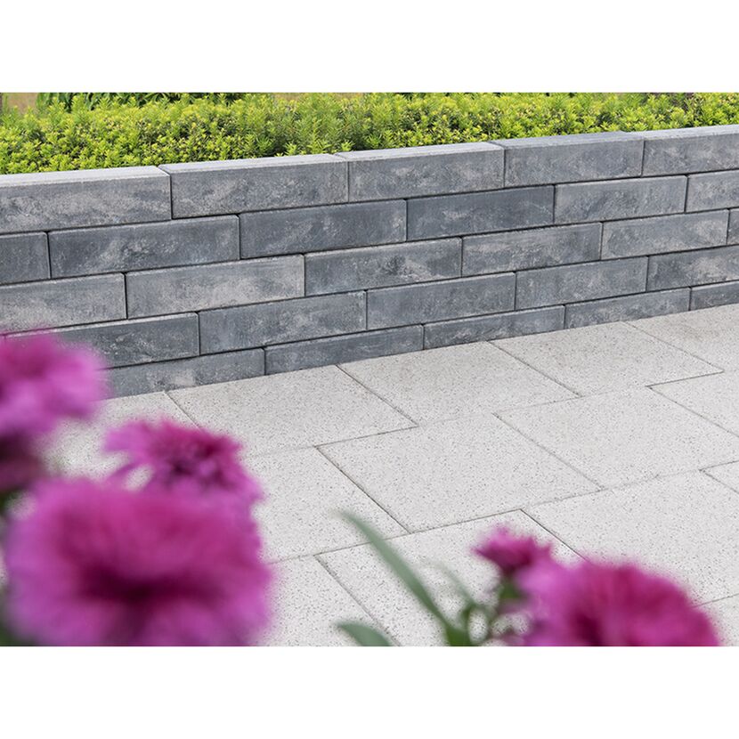 Graue Gartenmauer mit Blumen