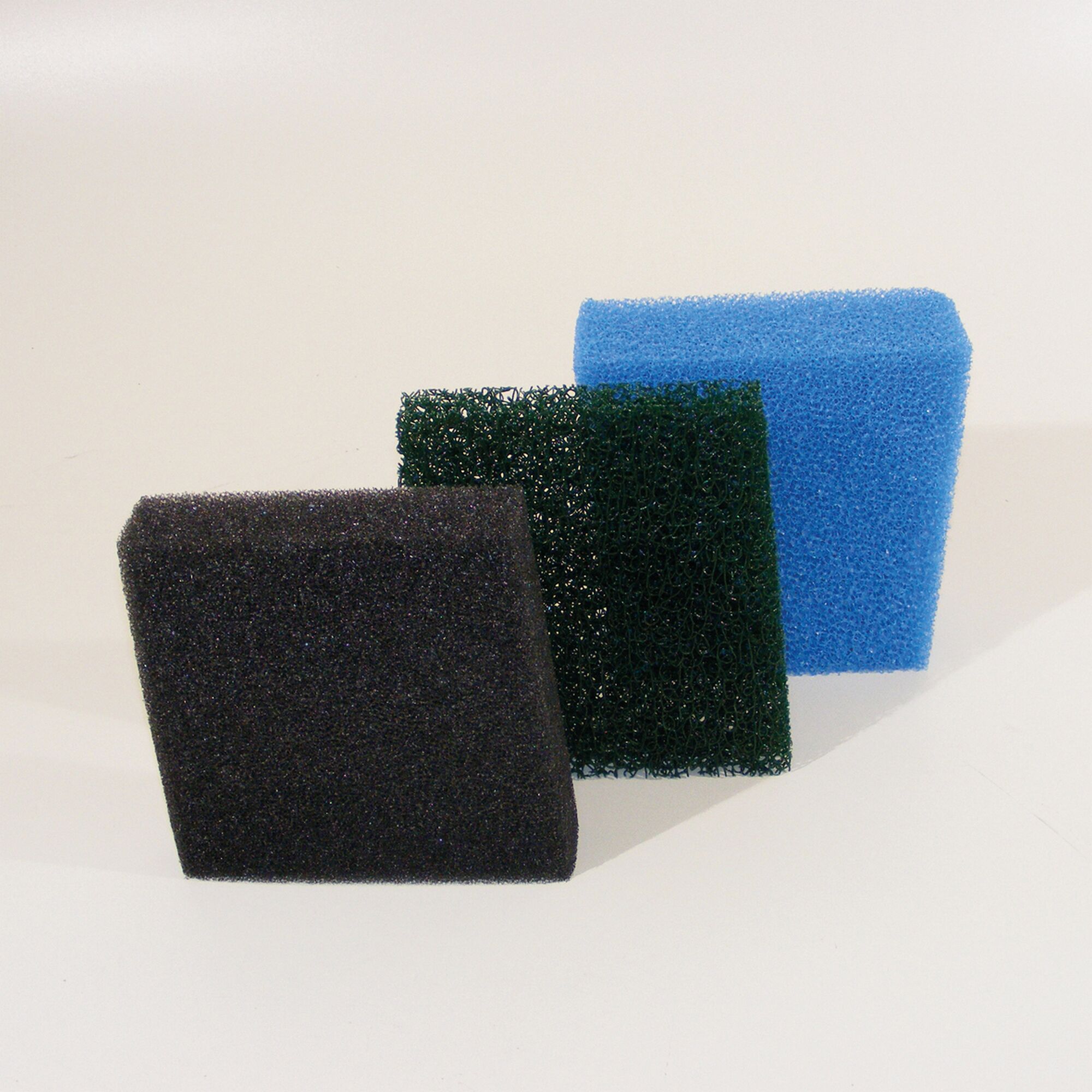 Drei Filterschwämme in schwarz, grün und blau