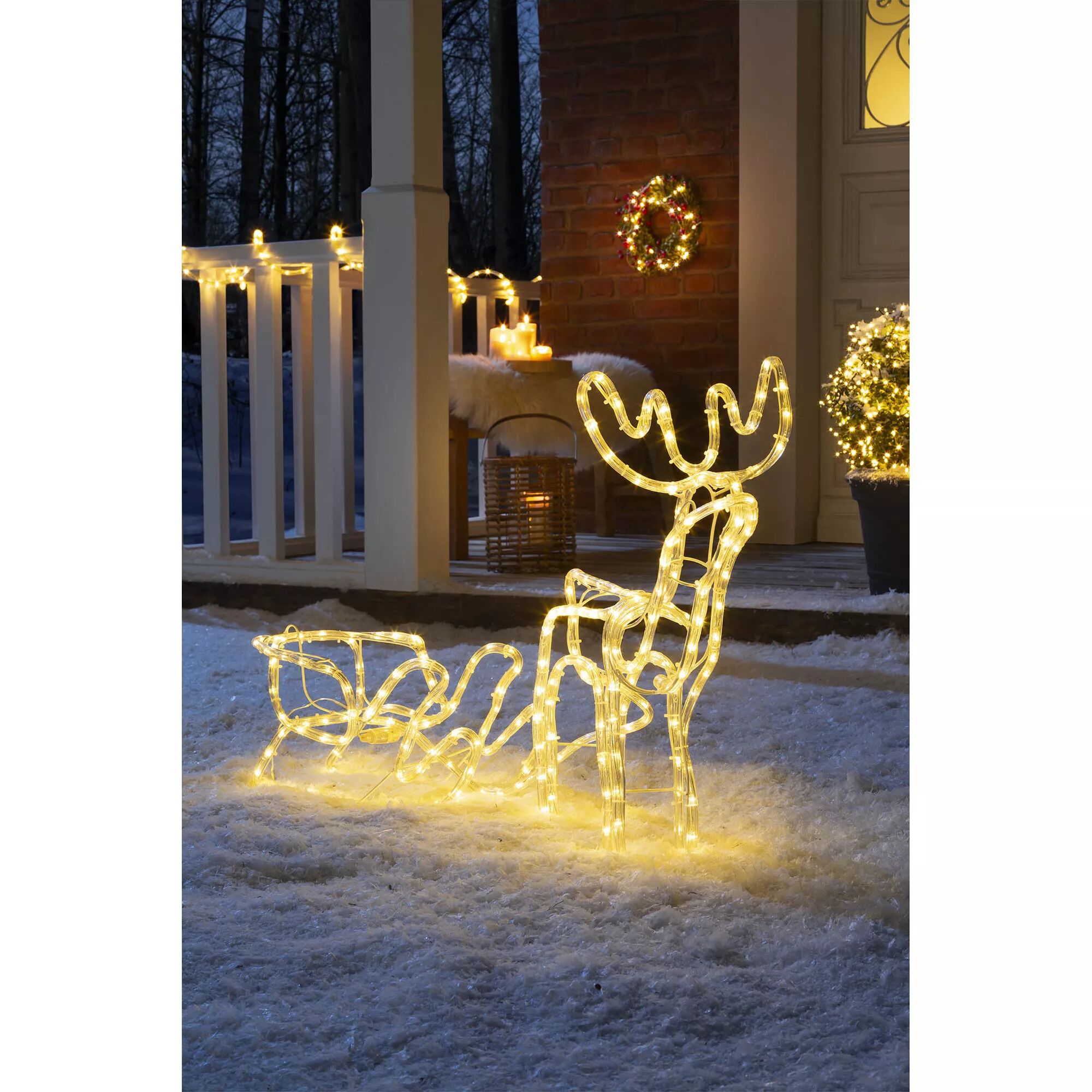 Leuchtender Elch mit Schlitten im Schnee