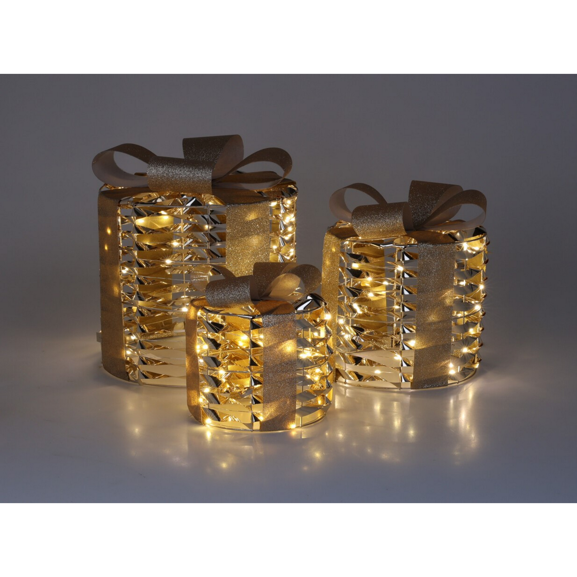 Drei goldene Geschenkboxen mit Lichtern