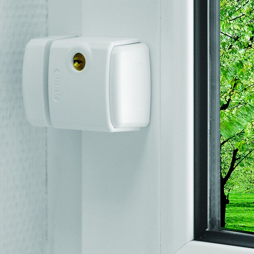 Weißes ABUS Fensterschloss FTS3003 W an einem Fensterrahmen.