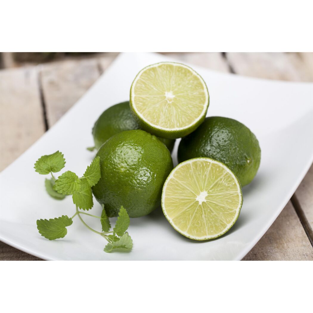 Limetten und Minzblätter auf einem weißen Teller
