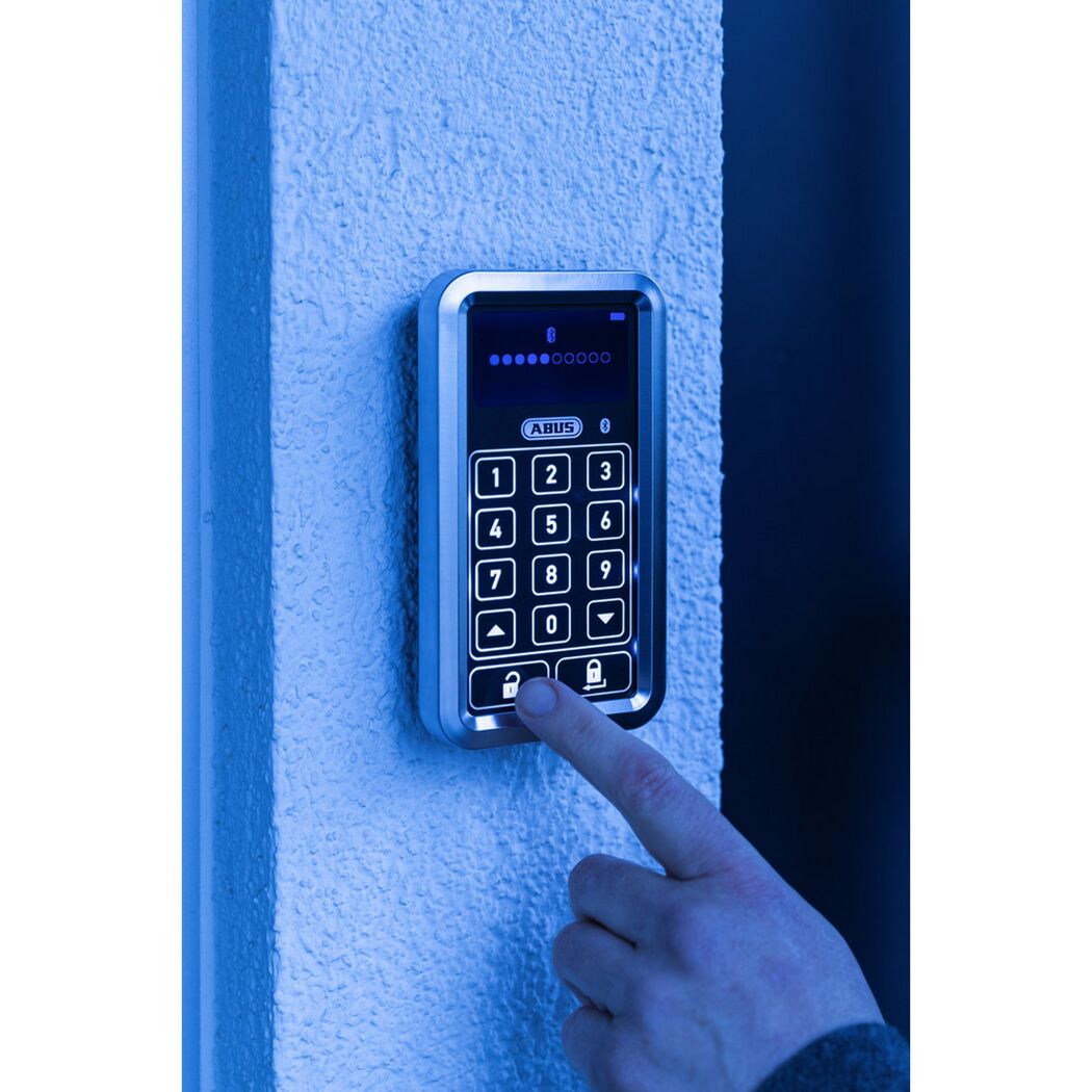 Person tippt Code in Türschloss ein