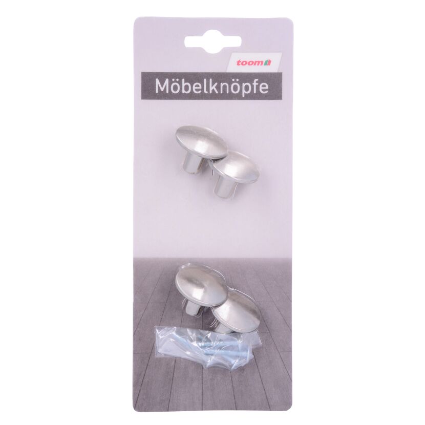 Vier silberne Möbelknöpfe und Schrauben in Verpackung.