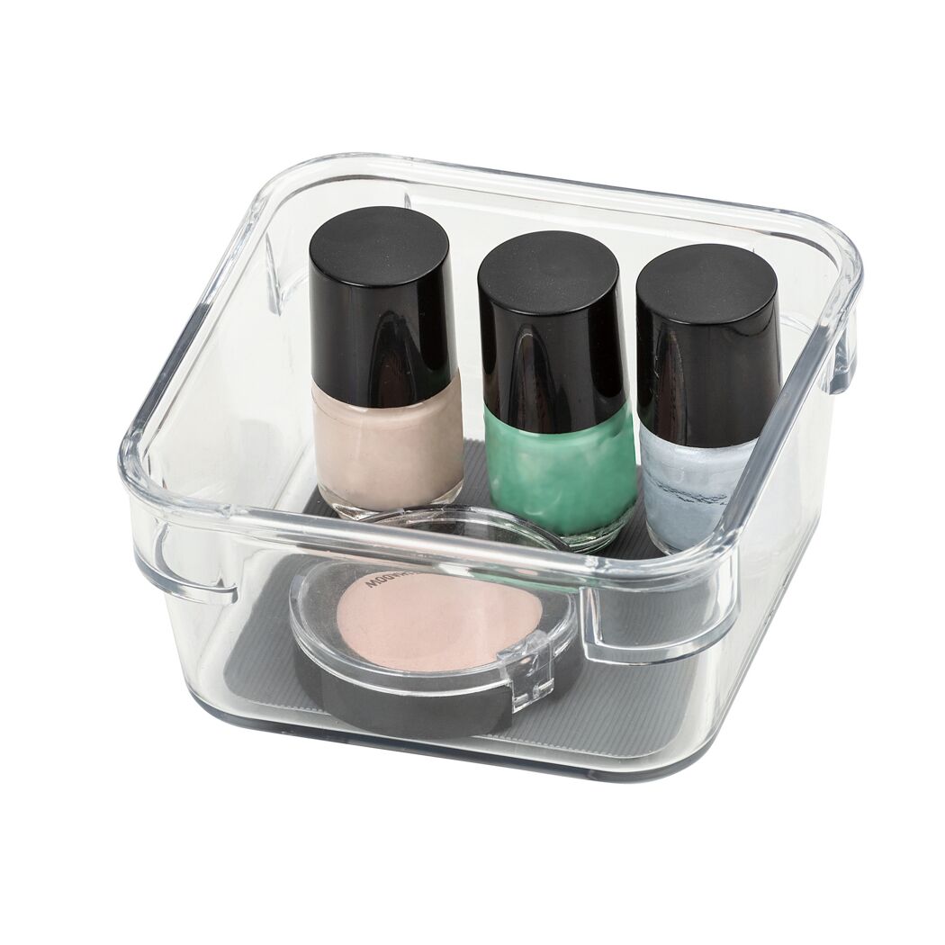Drei Nagellackfläschchen und ein Make-up-Döschen in einem durchsichtigen Organizer