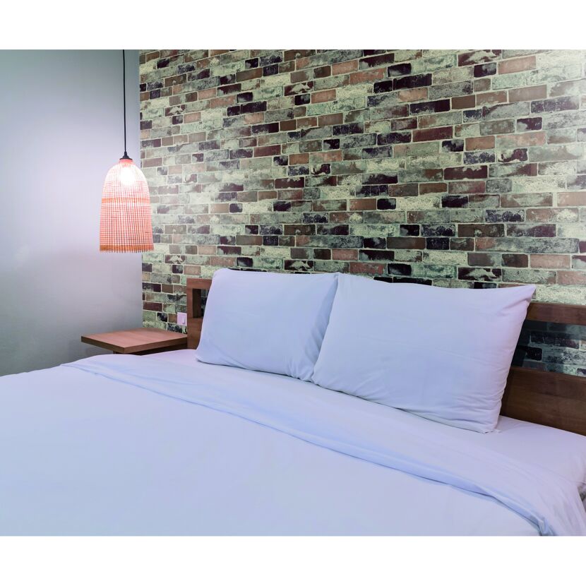 Bett mit weißer Bettwäsche und Bambuslampe