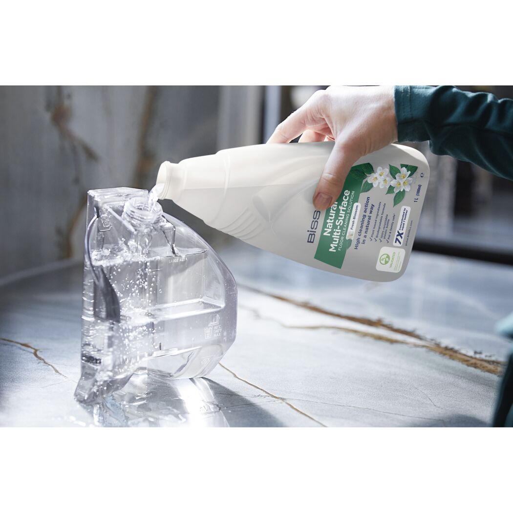 Bissell Natural Multi-Surface Reiniger wird in einen Behälter gegossen