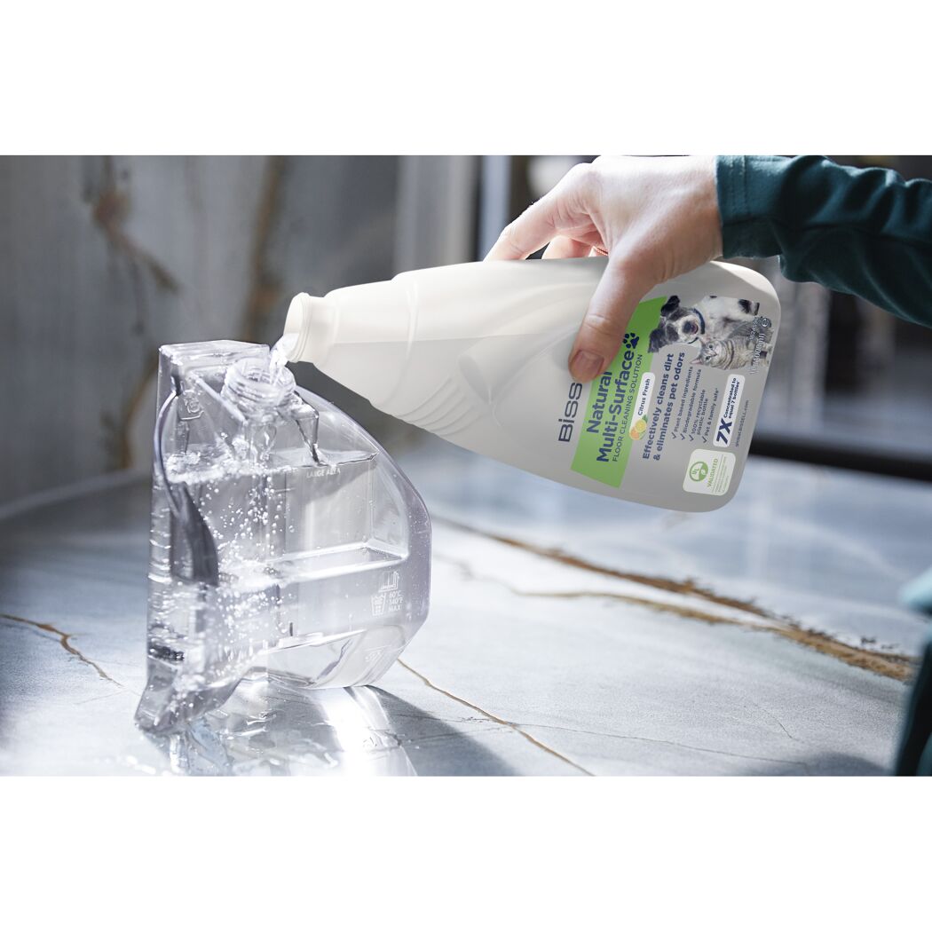 Bissell Natural Multi-Surface Reiniger wird in einen Wassertank gegossen.