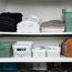 Ordentlich gefaltete Kleidung und Accessoires in einem Schrank.