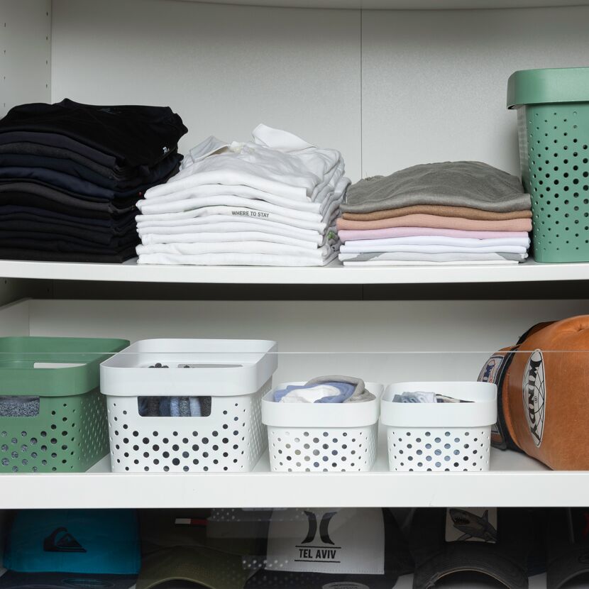 Ordentlich gefaltete Kleidung und Accessoires in einem Schrank.