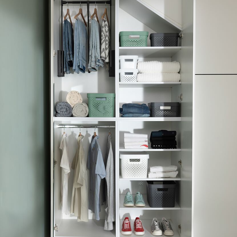 Kleiderschrank mit Kleidung, Schuhen und Handtüchern.