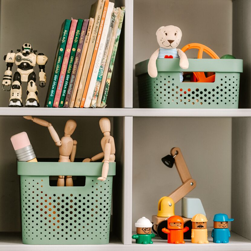 Spielzeug und Bücher in einem Kinderzimmerregal.