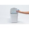 Hand wirft Plastikflasche in weißen Abfalleimer