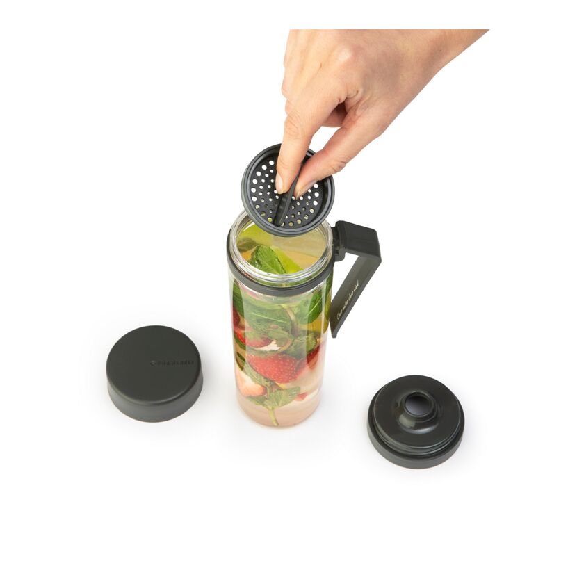 Person legt Sieb auf Trinkflasche mit Früchten und Minze.