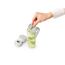 Person hält Sieb über Trinkflasche mit Wasser, Zitrone und Minze