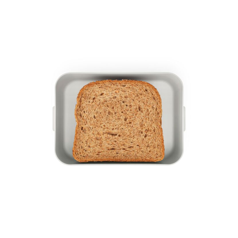 Eine Scheibe Vollkornbrot in einer hellgrauen Lunchbox.