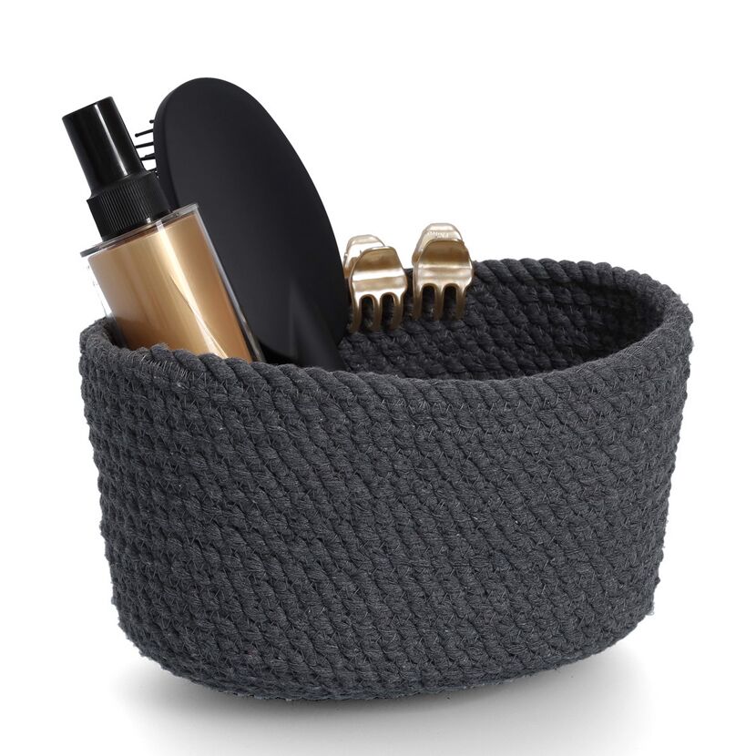 Haarbürste und Stylingprodukte im Korb