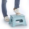 Person stellt Fuß auf blauen Klapphocker