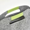 Graue Filztasche mit grünen Henkeln