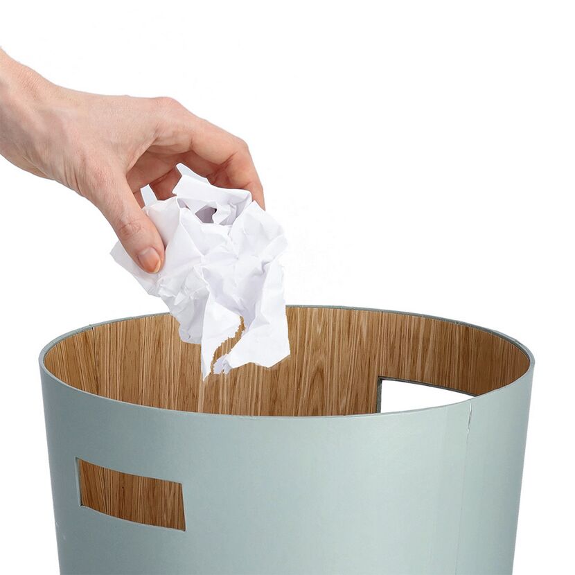 Hand wirft Papier in Mülleimer