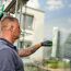 Person reinigt Fenster mit Einwascher
