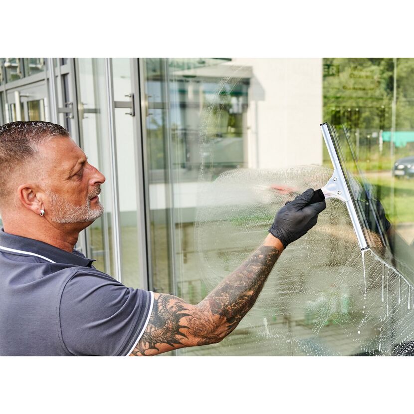Person reinigt Fenster mit Abzieher.