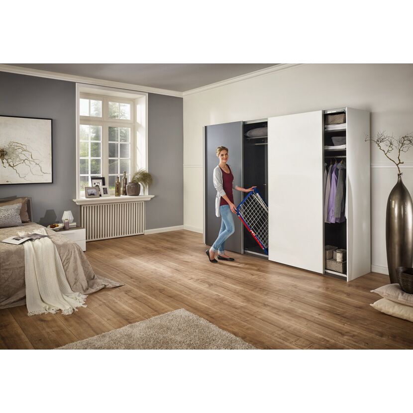 Person nimmt Wäscheständer Pegasus 150 aus einem Schrank.