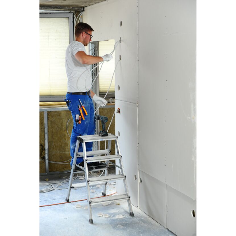 Person verlegt Kabel in der Wand.