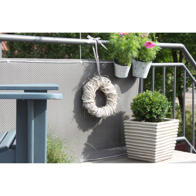 Balkon mit Sichtschutz, Deko und Pflanzen.