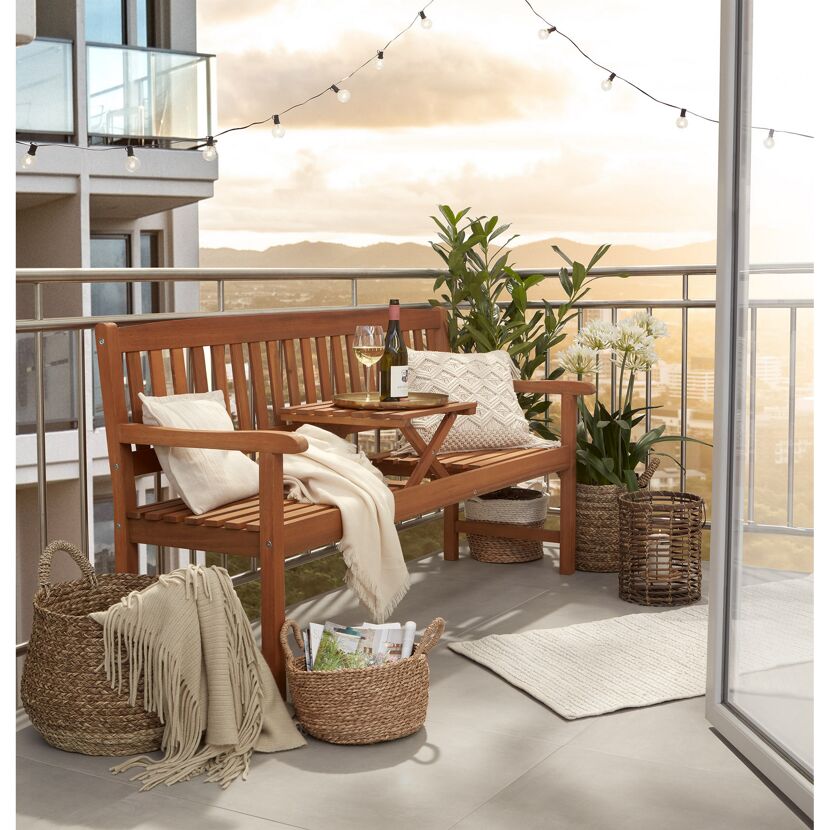 Holzbank mit Tisch auf Balkon, Deko, Korb und Pflanzen
