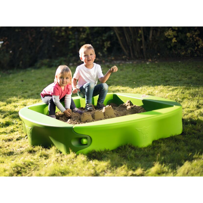 Zwei Kinder spielen in einem grünen BIG-Sandkasten.