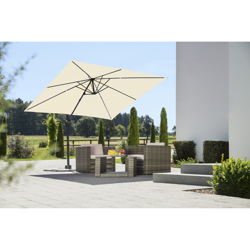 Beigefarbener quadratischer Sonnenschirm über einer Sitzgruppe im Garten