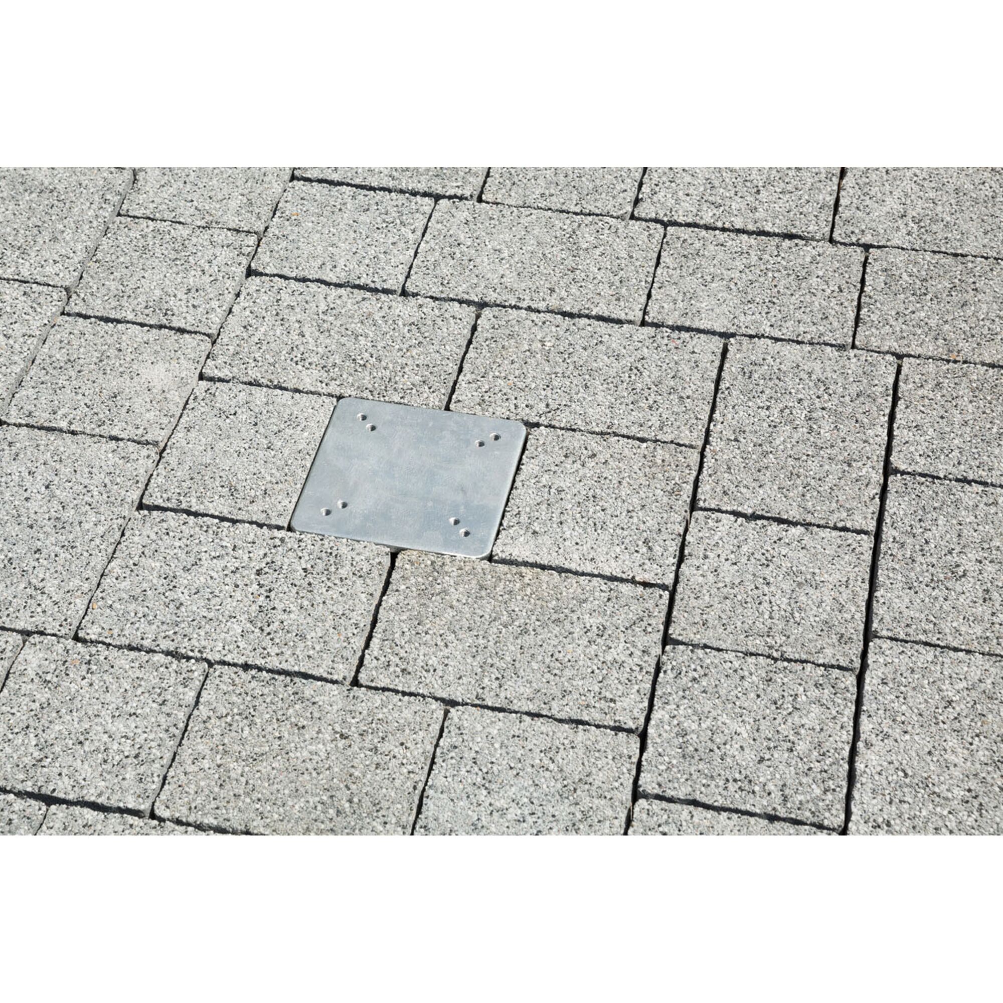 Metallplatte auf grauem Pflasterstein