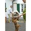 Person legt Holz in den Gartenkamin San Remo